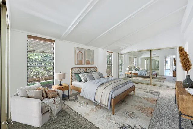 a bedroom with a bed and a large window