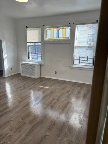 a view of a kitchen with wooden floor and a window