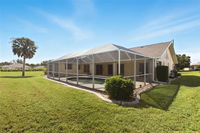 a view of a house with backyard and sitting area