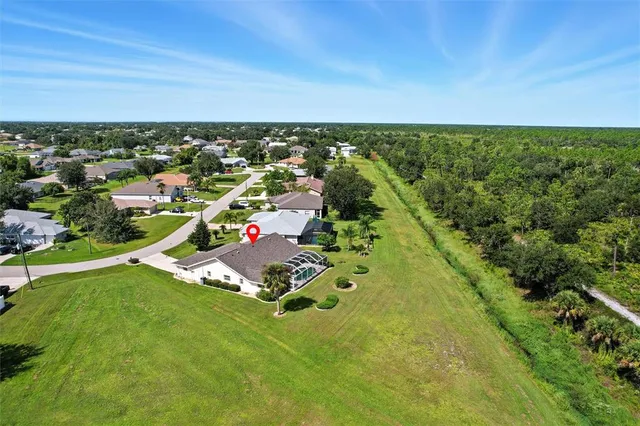 an aerial view of residential houses with outdoor space and trees