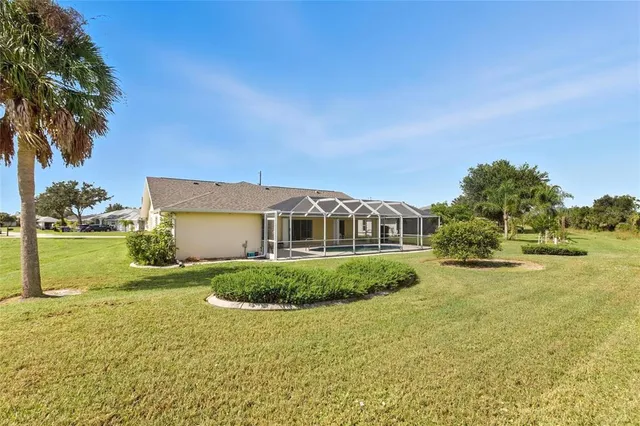a view of a big house with a big yard and palm trees