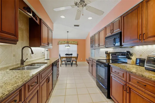 a kitchen with stainless steel appliances granite countertop a sink stove and cabinets