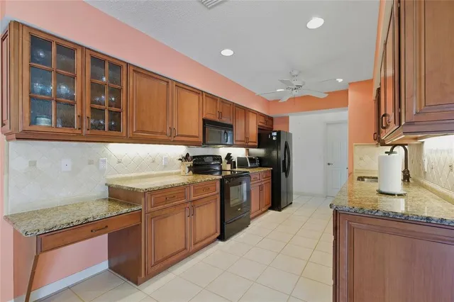 a kitchen with stainless steel appliances granite countertop a stove sink and cabinets