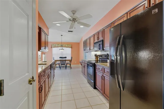 a kitchen with stainless steel appliances granite countertop a refrigerator and a stove