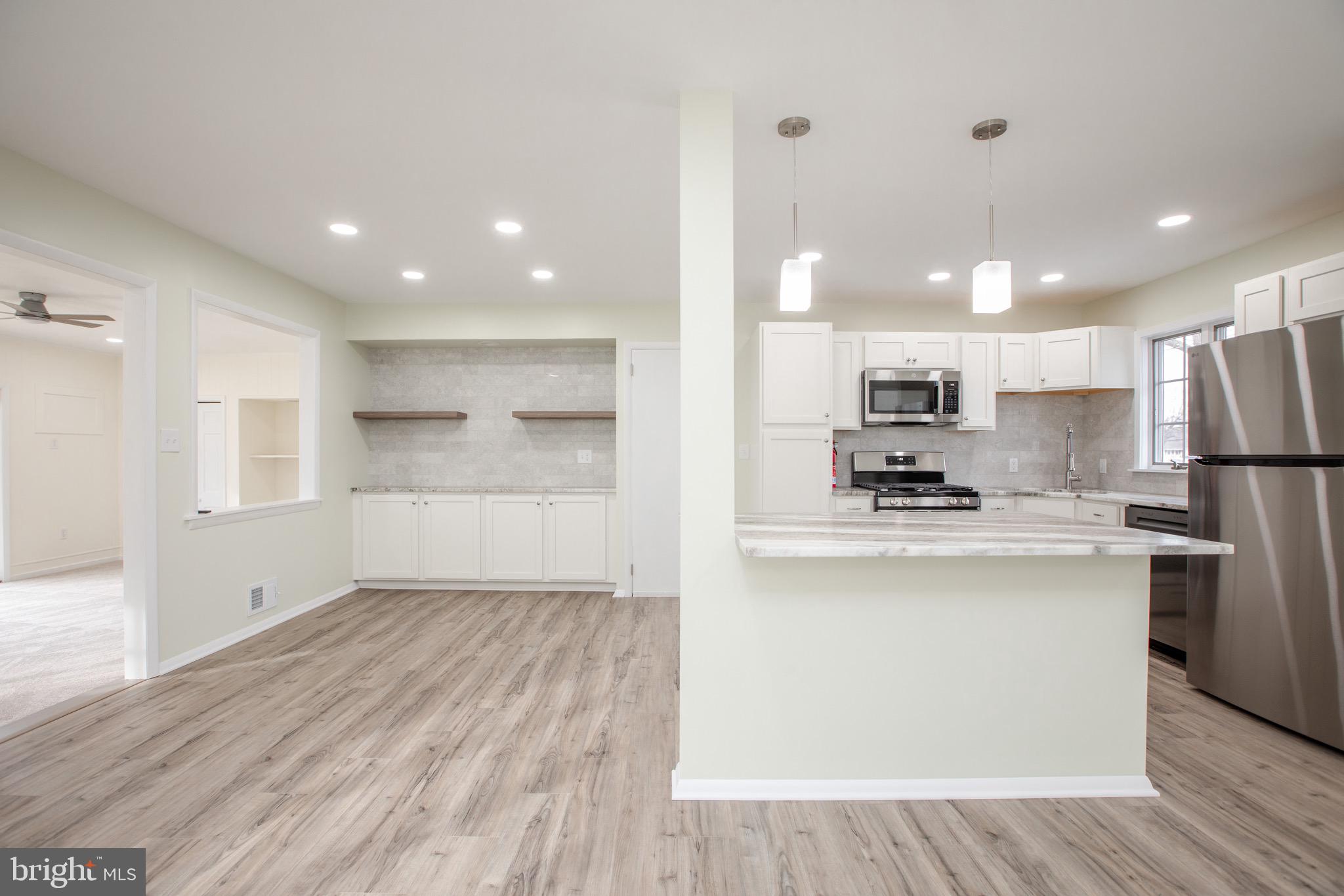 21 Rolling Lane Hamilton, NJ 08690 - Photo 15 of 40 a kitchen with stainless steel appliances kitchen island wooden cabinets and refrigerator