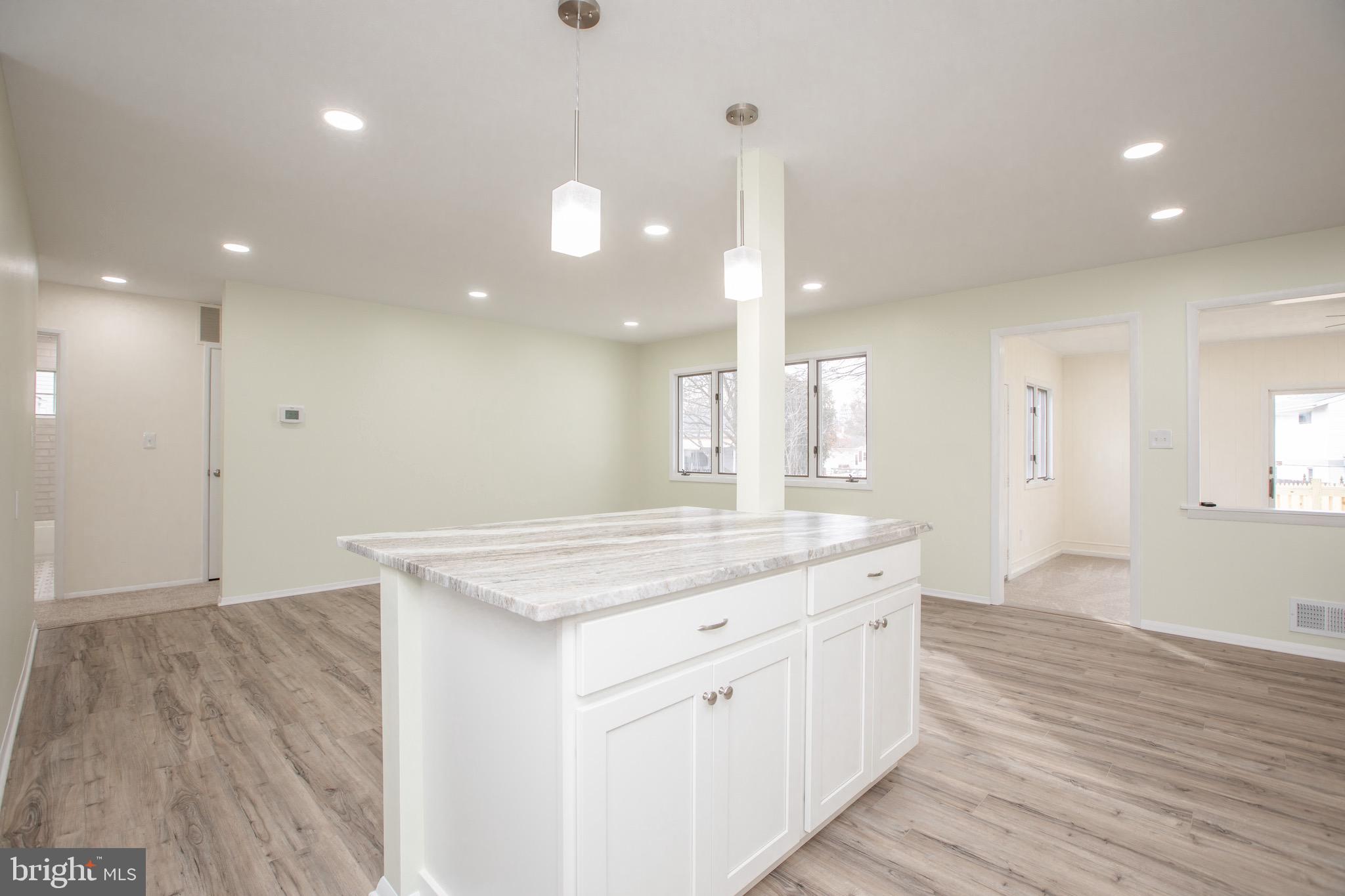 21 Rolling Lane Hamilton, NJ 08690 - Photo 18 of 40 a hall with kitchen island white cabinets and wooden floor