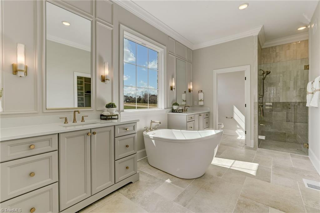6806 Brennan Way Oak Ridge, NC 27310 - Photo 5 of 50 luxurious primary en suite with standalone soaking tub and dual vanities, walk in tile shower and seperate water closet