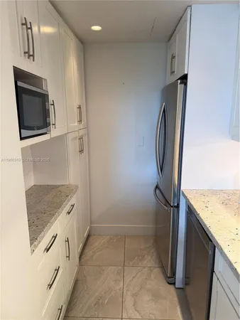 a view of kitchen with a sink and a refrigerator