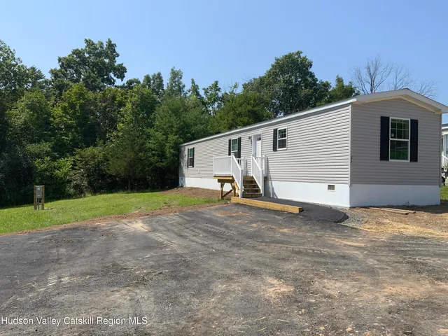 a view of a house with backyard and trees