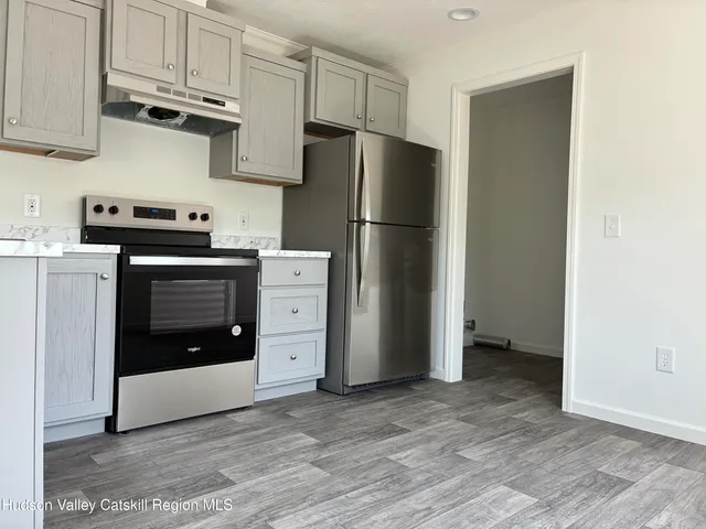 a kitchen with stainless steel appliances granite countertop a refrigerator and a stove