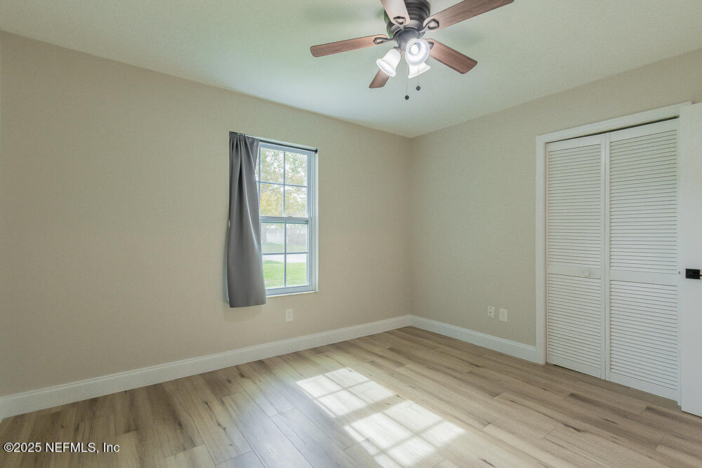 2168 Minorcan Street Middleburg, FL 32068 - Photo 14 of 24 an empty room with a chandelier fan and windows