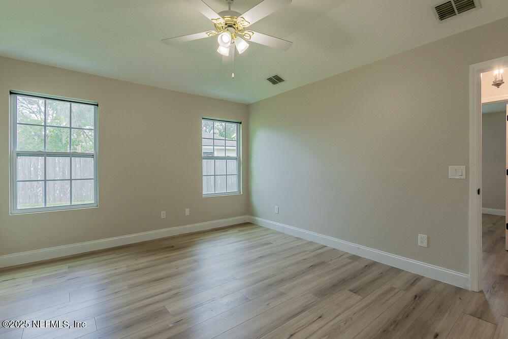 2168 Minorcan Street Middleburg, FL 32068 - Photo 17 of 24 a view of an empty room with wooden floor and a window