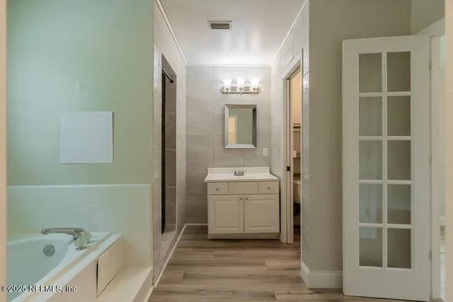 a bathroom with a bathtub sink and mirror