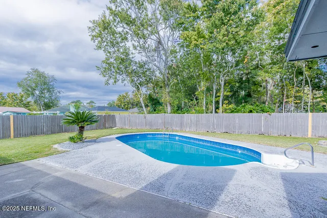 a view of a backyard with swimming pool