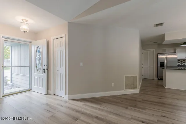 a view of a kitchen with a sink and refrigerator