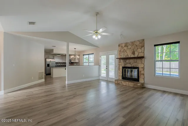 a view of empty room with wooden floor and fireplace