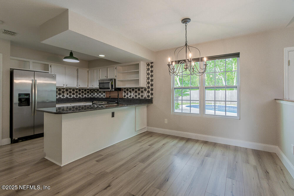 2168 Minorcan Street Middleburg, FL 32068 - Photo 8 of 24 a kitchen with granite countertop a refrigerator and wooden floor