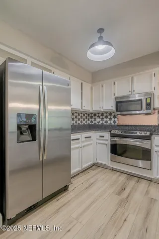 a kitchen with a refrigerator and a stove top oven