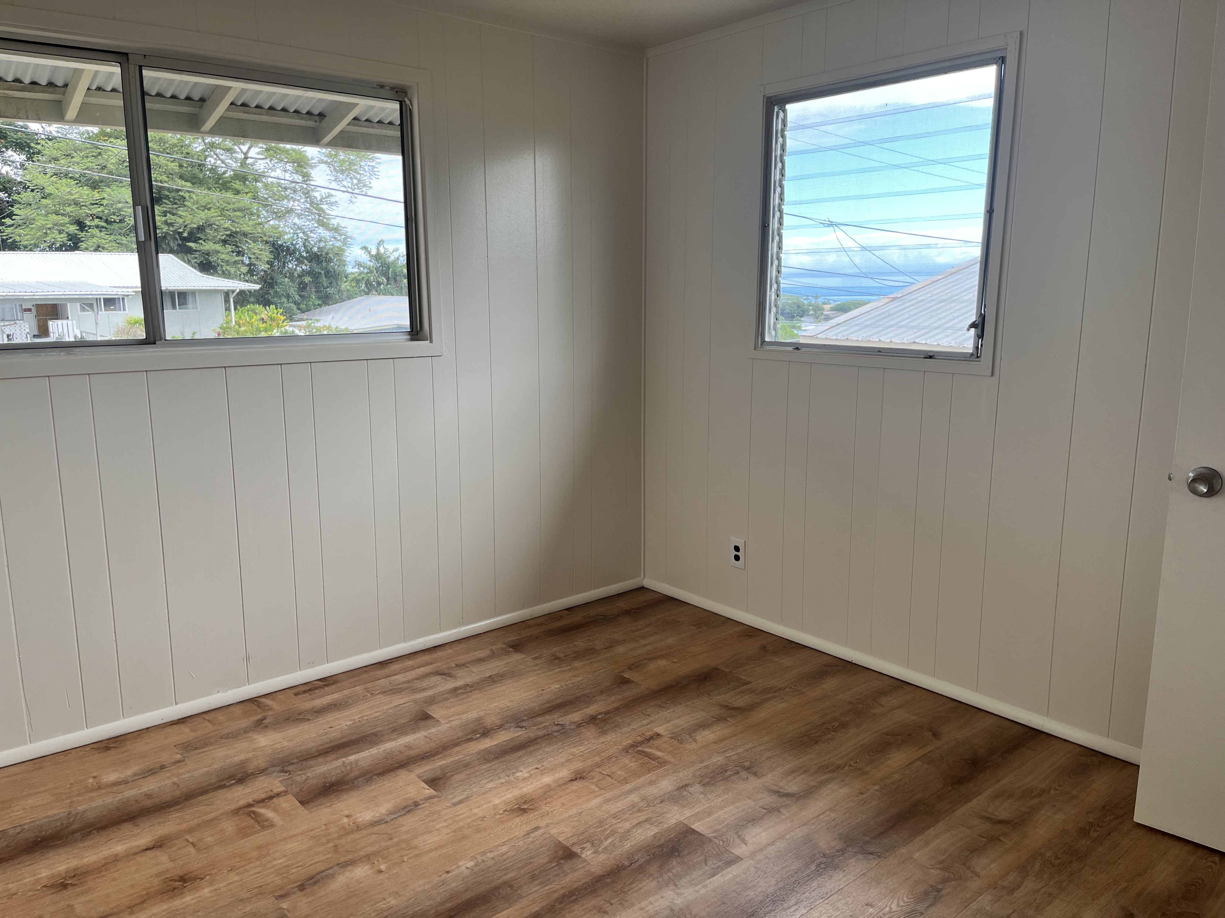 483 Hoopuni Way Hilo, HI 96720 - Photo 11 of 14 an empty room with wooden floor and windows