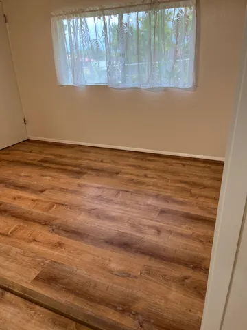 a view of a room with wooden floor and windows