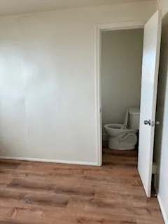 a view of a room with wooden floor and bathroom