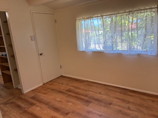 483 Hoopuni Way Hilo, HI 96720 - Photo 10 of 14 an empty room with wooden floor and windows