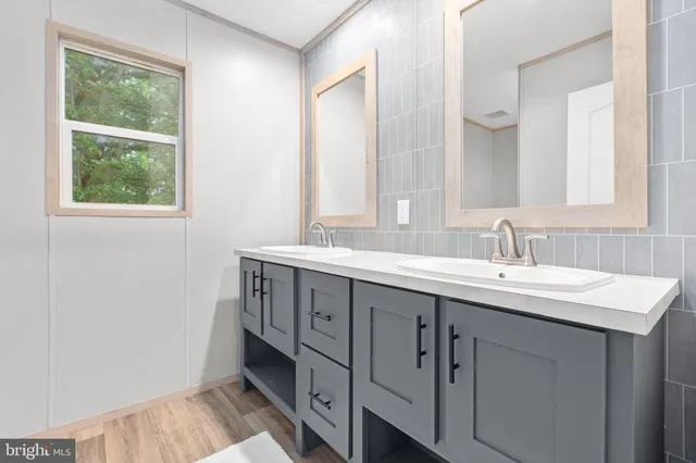 a bathroom with a double vanity sink and a mirror