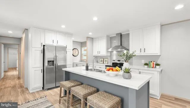 a kitchen with stainless steel appliances granite countertop a sink refrigerator and cabinets
