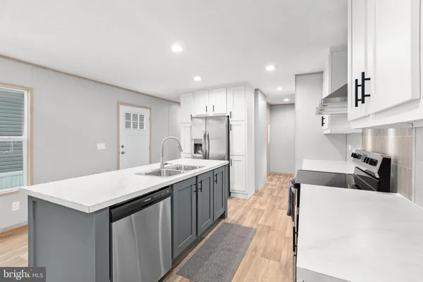 a large kitchen with kitchen island a sink a counter space and stainless steel appliances