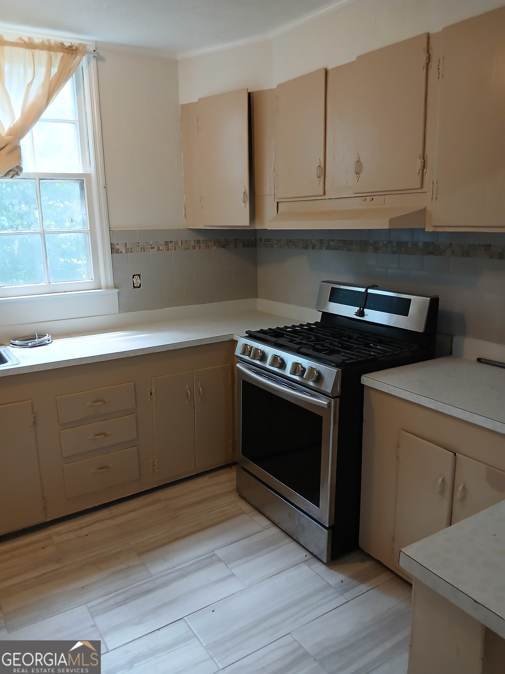 678 Dixie Avenue Macon, GA 31206 - Photo 12 of 19 a kitchen with granite countertop wooden cabinets and a stove
