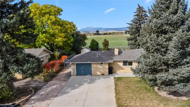 a aerial view of a house with a garden and tree