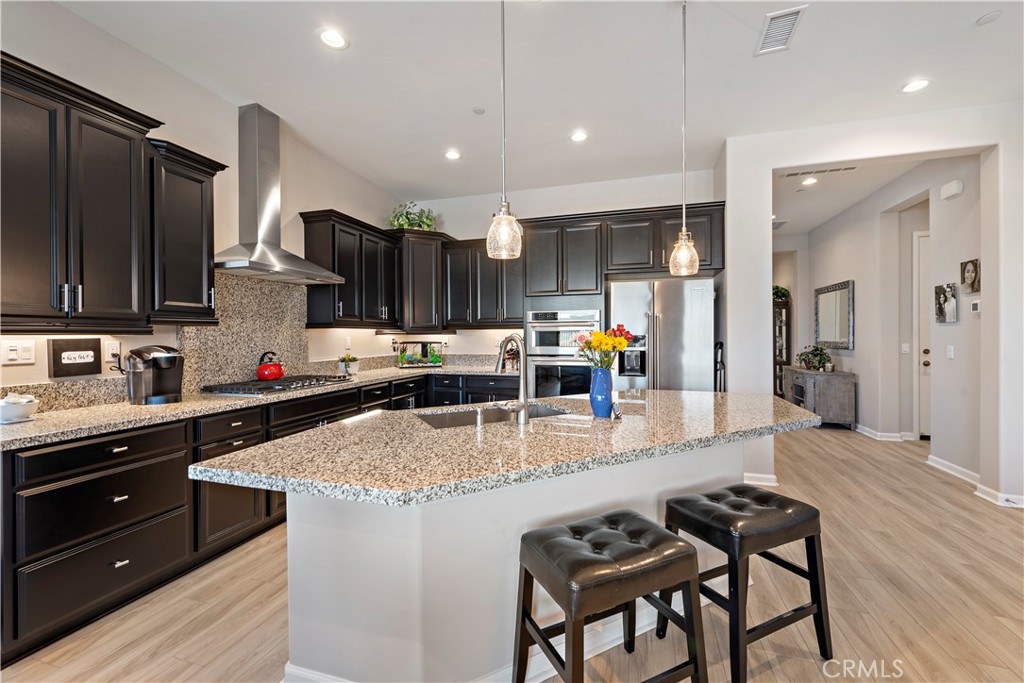 24301 Overlook Drive Corona, CA 92883 - Photo 7 of 20 a kitchen with stainless steel appliances granite countertop a stove top oven a sink dishwasher and cabinets with wooden floor