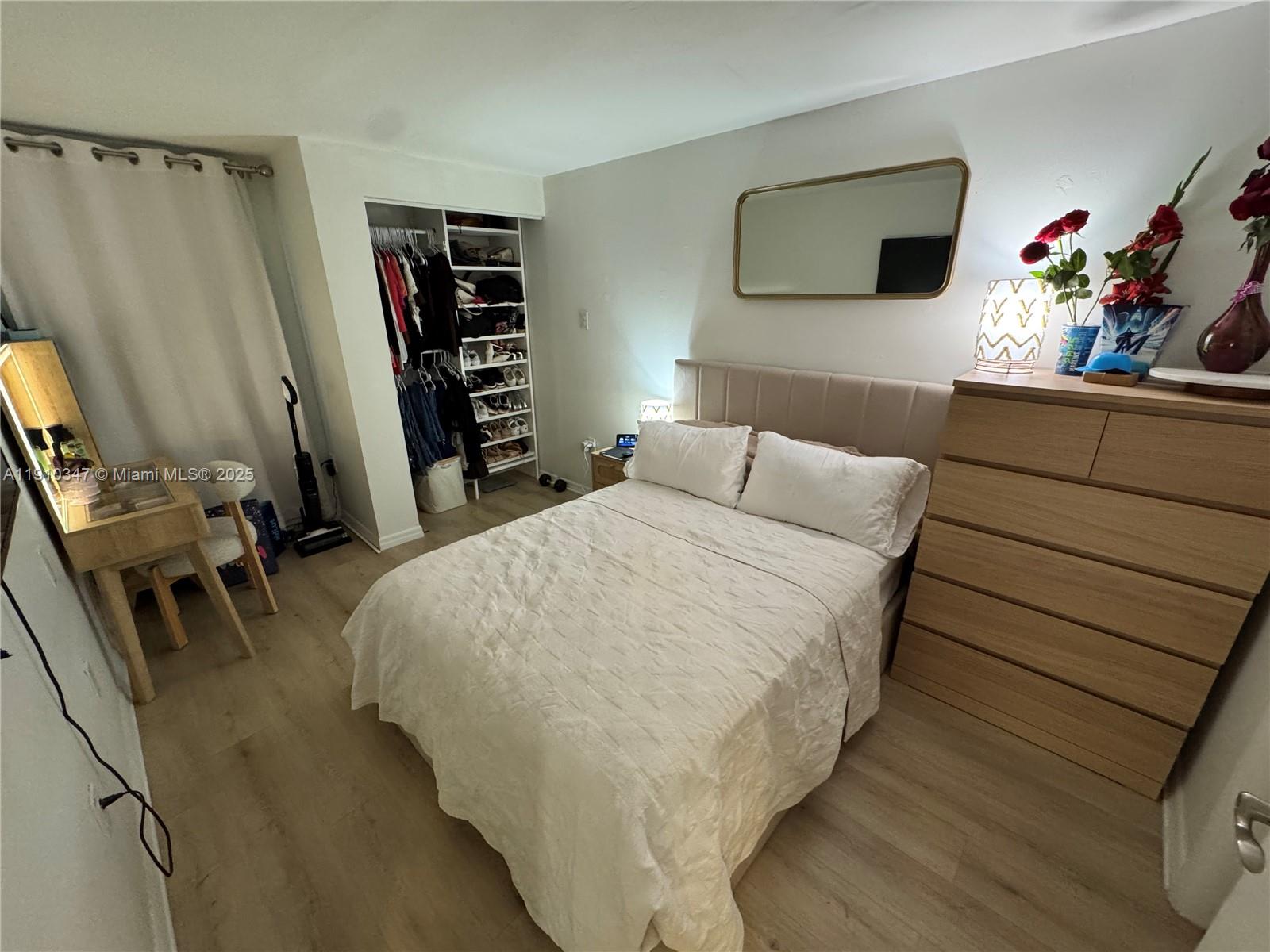 a bedroom with a bed a flat screen tv and dresser