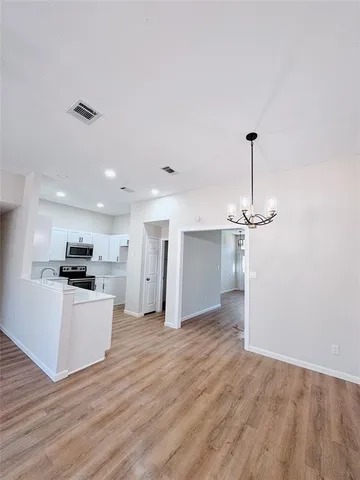 a view of a kitchen with a sink and wooden floor