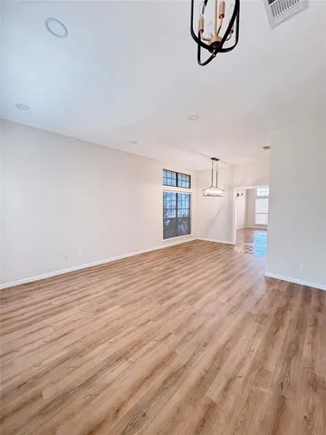 a view of empty room with wooden floor and ceiling fan