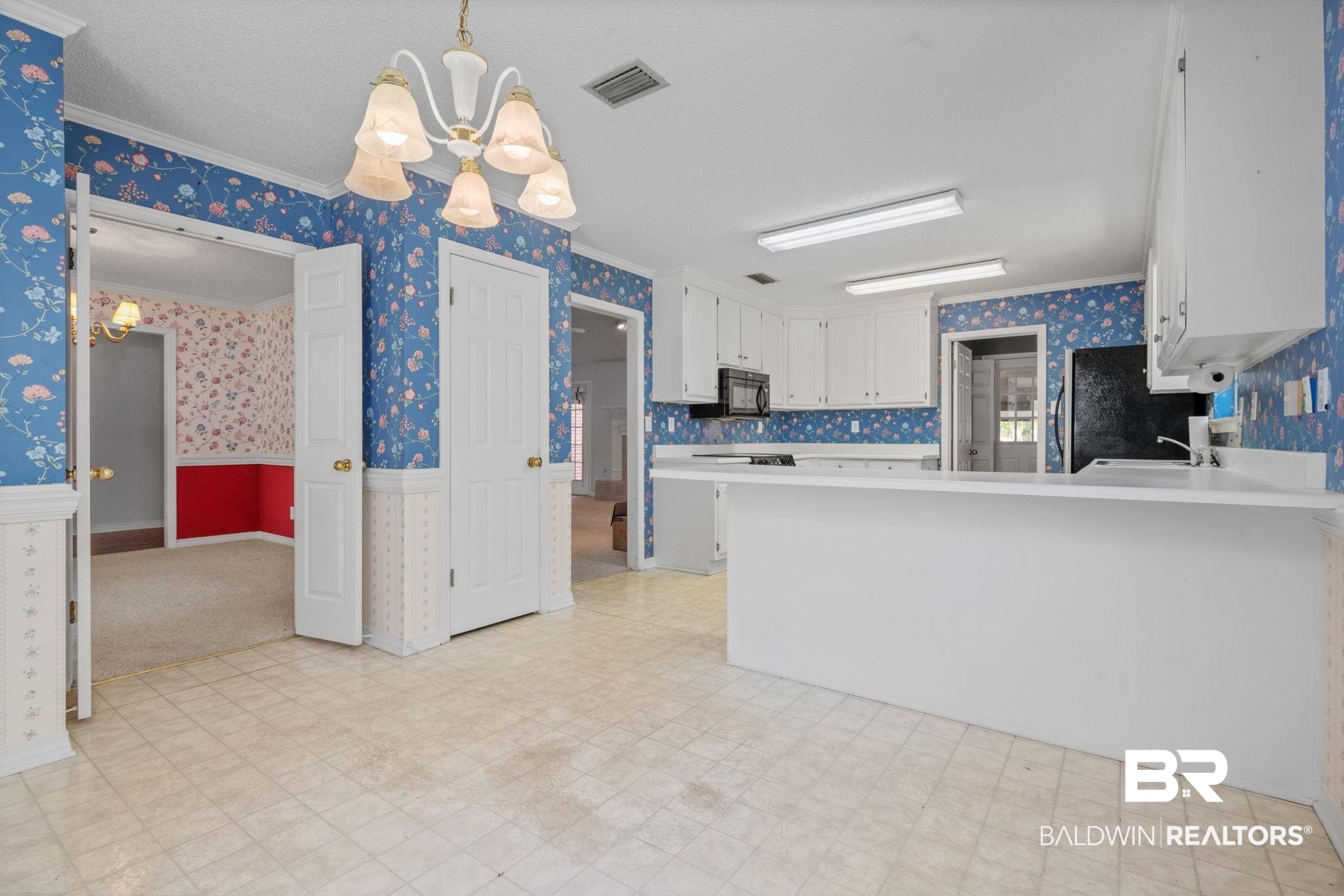 1340 Wellsley Court Mobile, AL 36695 - Photo 21 of 37 Kitchen with wallpapered walls, white cabinetry, light countertops, a chandelier, and hanging light fixtures