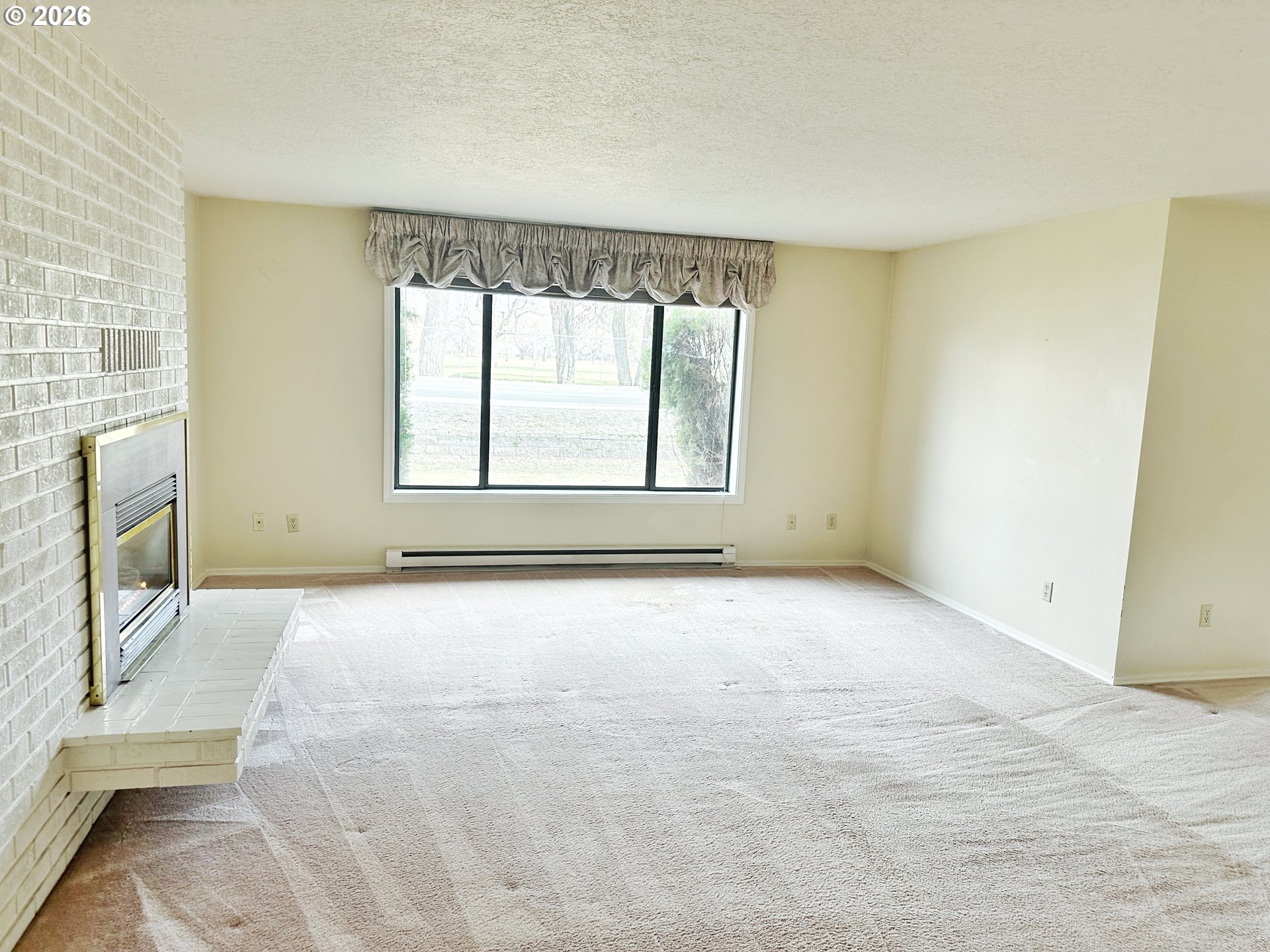 10710 South McAlister Road Island City, OR 97850 - Photo 5 of 22 an empty room with a fireplace and windows