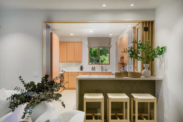 a kitchen with a sink window and cabinets