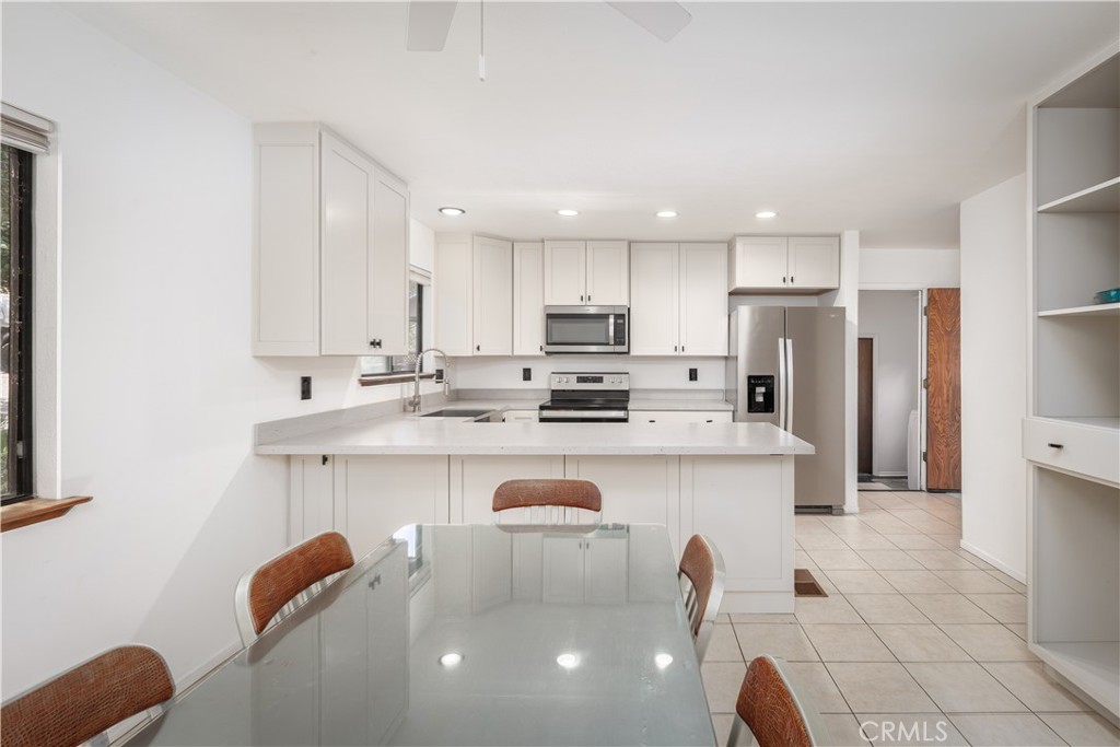 3175 Arena Avenue Atascadero, CA 93422 - Photo 12 of 40 a kitchen with stainless steel appliances granite countertop a sink a stove a refrigerator cabinets and a dining table