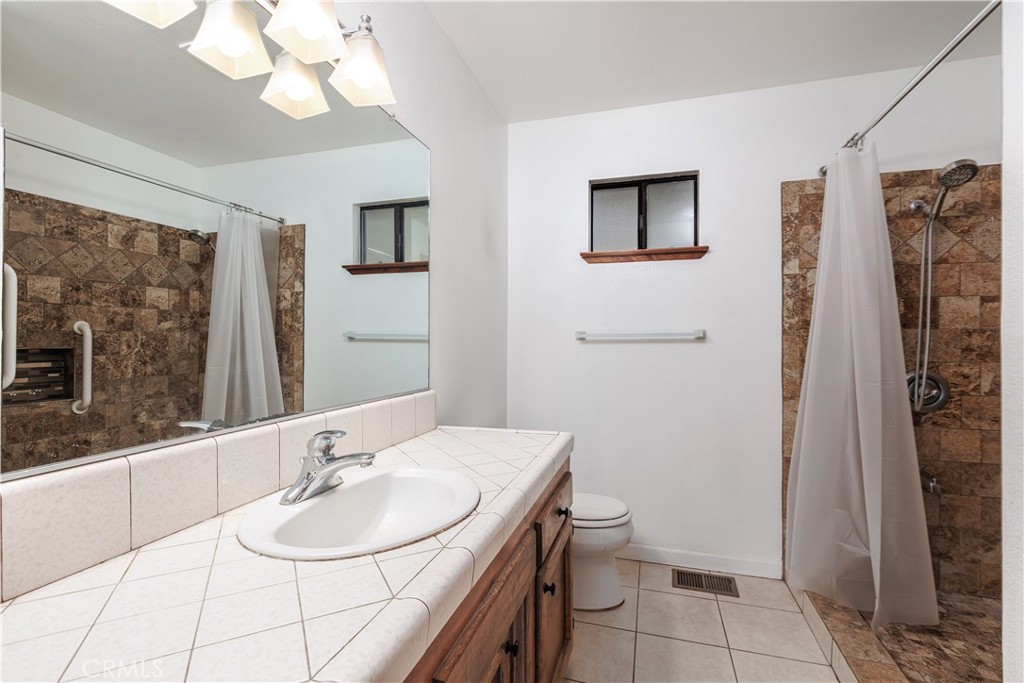 3175 Arena Avenue Atascadero, CA 93422 - Photo 18 of 40 a bathroom with a sink a toilet and mirror