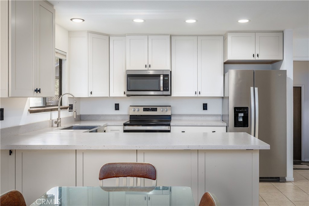 3175 Arena Avenue Atascadero, CA 93422 - Photo 10 of 40 a kitchen with stainless steel appliances granite countertop a refrigerator a stove a sink a microwave and white cabinets
