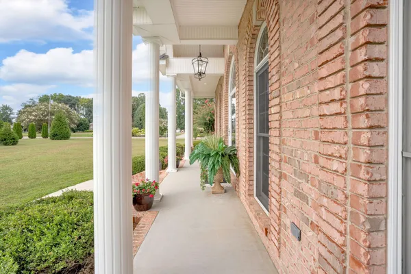 a view of a dining room with furniture a chandelier and wooden floor