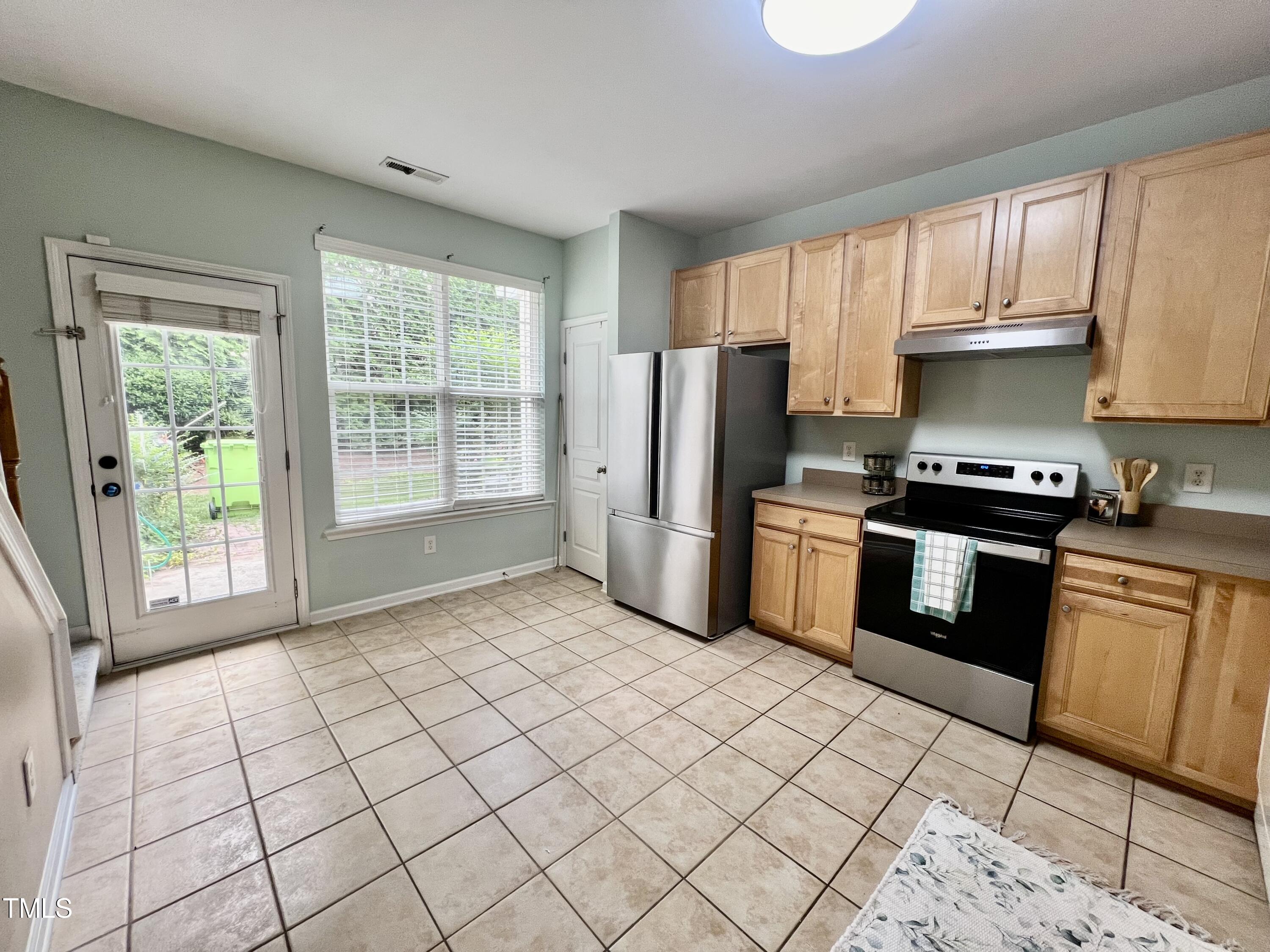 7730 Winners Edge Street Raleigh, NC 27617 - Photo 8 of 20 a kitchen with stainless steel appliances granite countertop a stove a sink dishwasher a refrigerator and cabinets with wooden floor