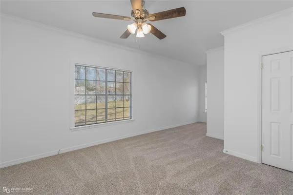 an empty room with windows and fan