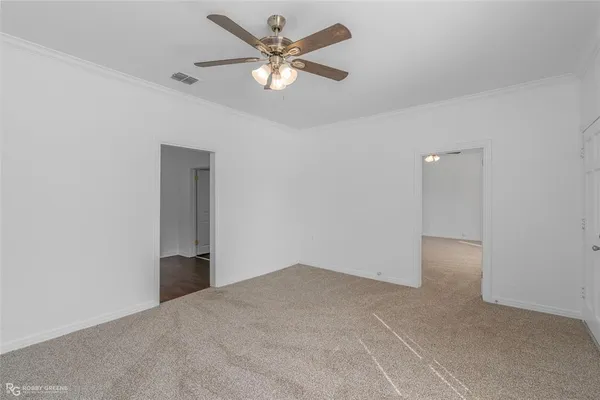 an empty room with closet and a ceiling fan