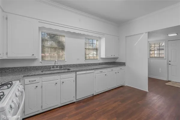 a kitchen with granite countertop white cabinets and a sink
