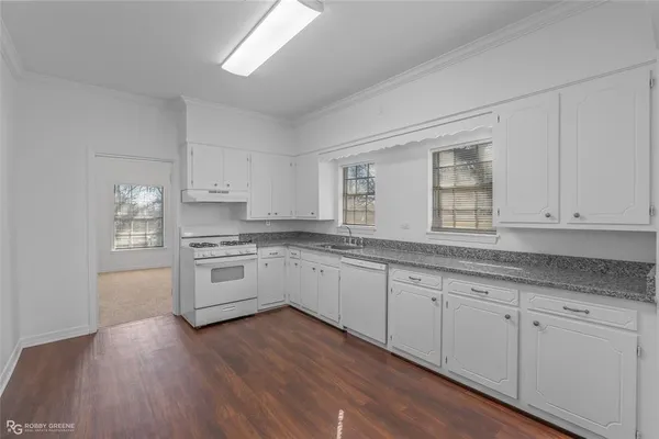a kitchen with granite countertop white cabinets and white appliances