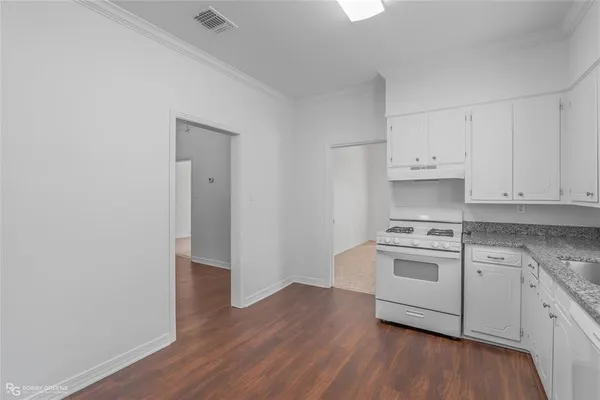 a kitchen with granite countertop white cabinets and white appliances