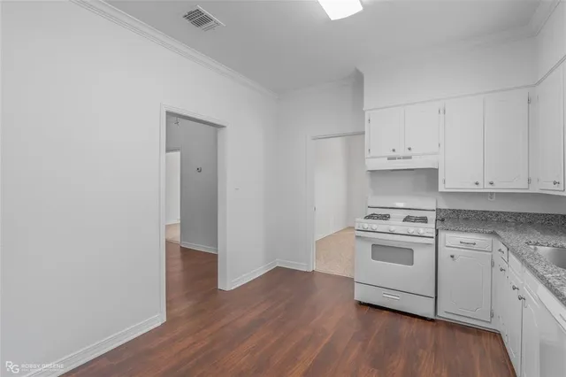 a kitchen with granite countertop white cabinets and white appliances