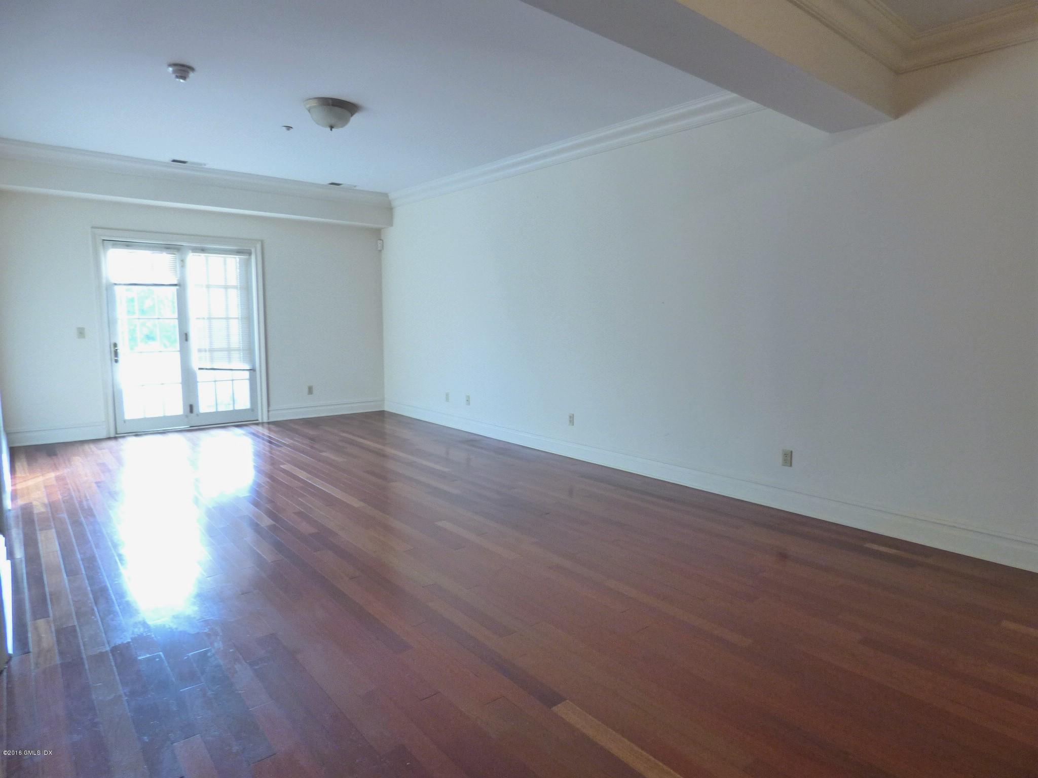 2 Dearfield Drive, Unit 2B Greenwich, CT 06831 - Photo 5 of 13 an empty room with wooden floor and windows